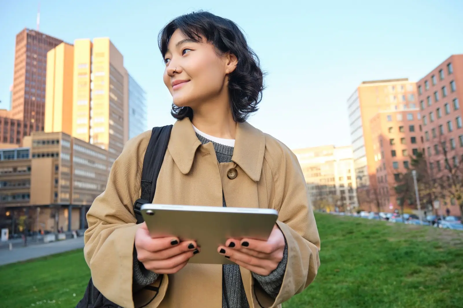 a international student girl holding her tablet looking left after school