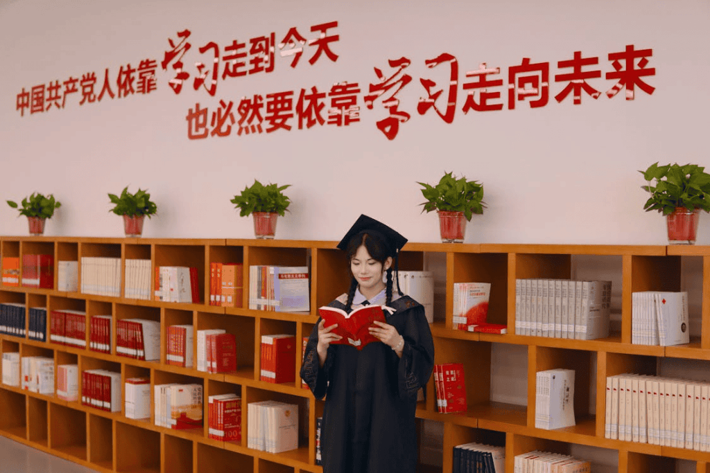 a Chinese university graduate reading in front of bookshelves