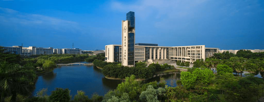 Guangzhou University (GZHU) campus with clock tower, lake, and lush greenery in Guangzhou, China
