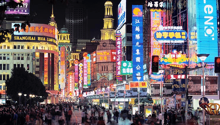Nanjing Road pedestrian street at night with neon lights and crowds in Shanghai, China