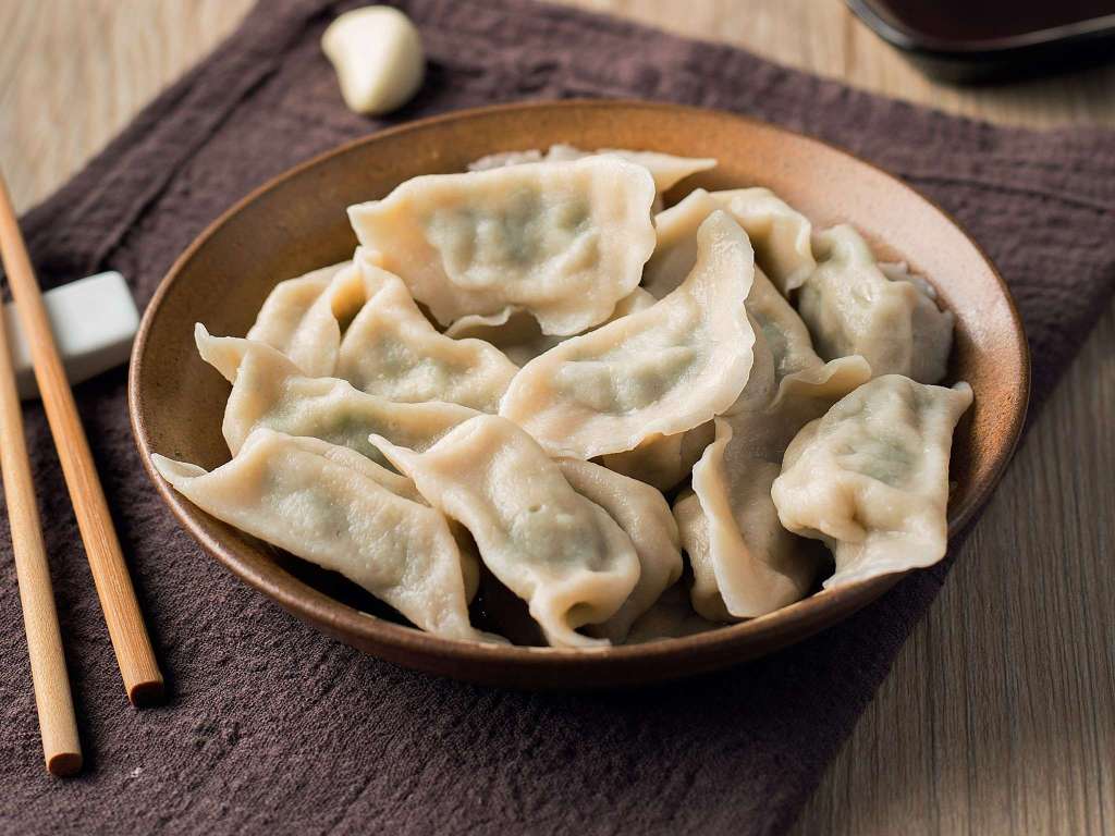 A bowl of Chinese dumplings jiaozi with chopsticks — traditional food in China