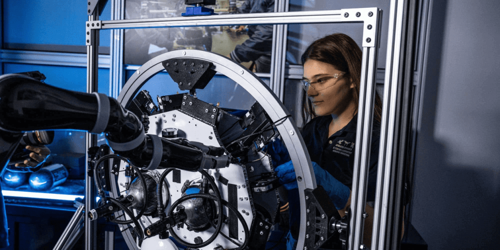 Aerospace engineering student working on spacecraft hardware at a university research lab in China